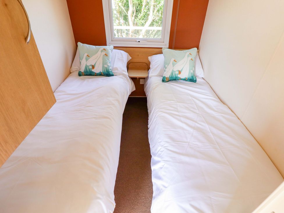 A bedroom with two single beds and a window at Ewe View