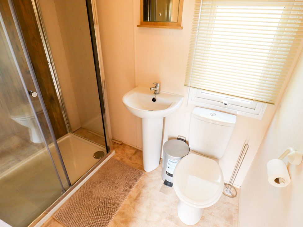 A bathroom with a shower, wash basin, and toilet at Ewe View