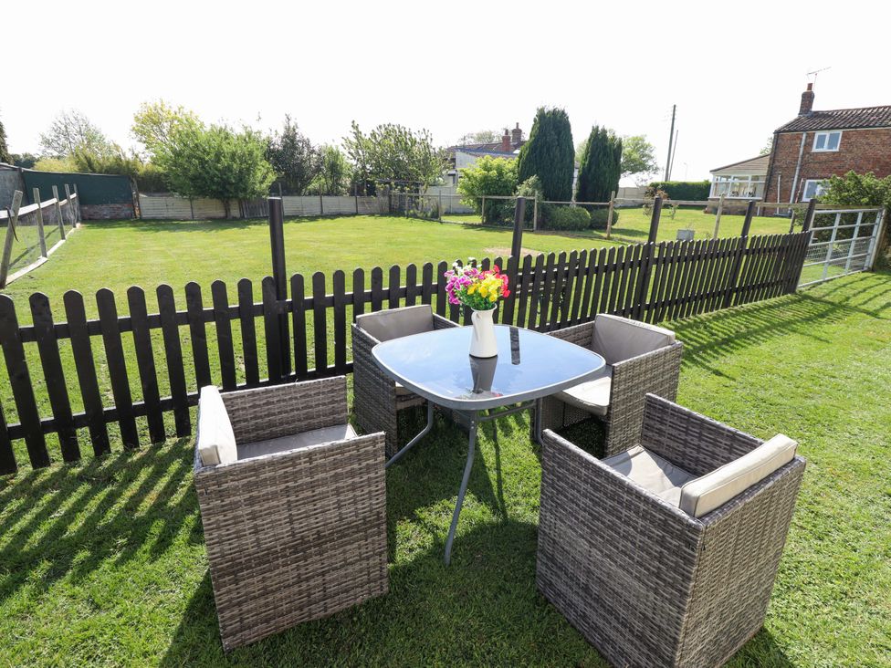 A garden with a table and chairs at Ewe View