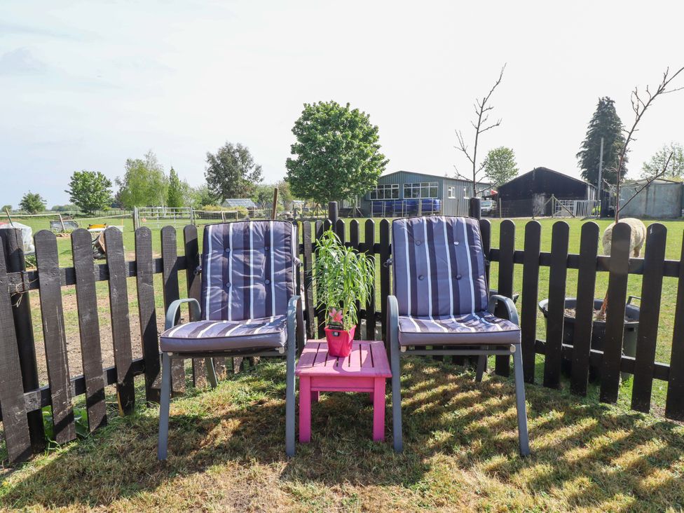 Two chairs and a table with a plant in an outdoor area at Ewe View