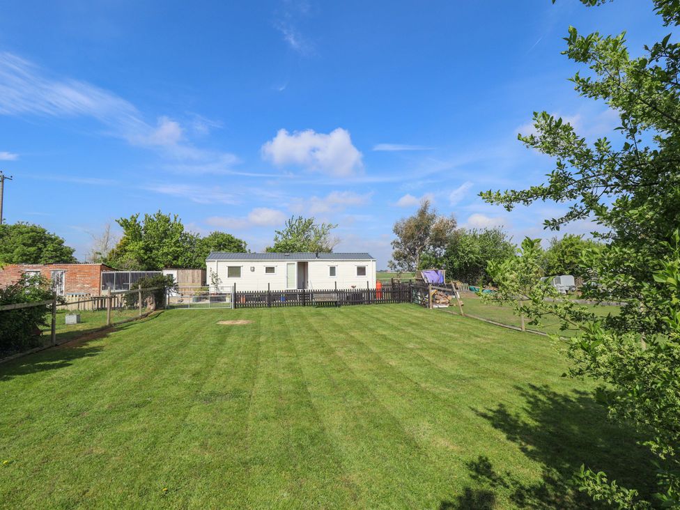 A garden with a mobile home and trees at Ewe View