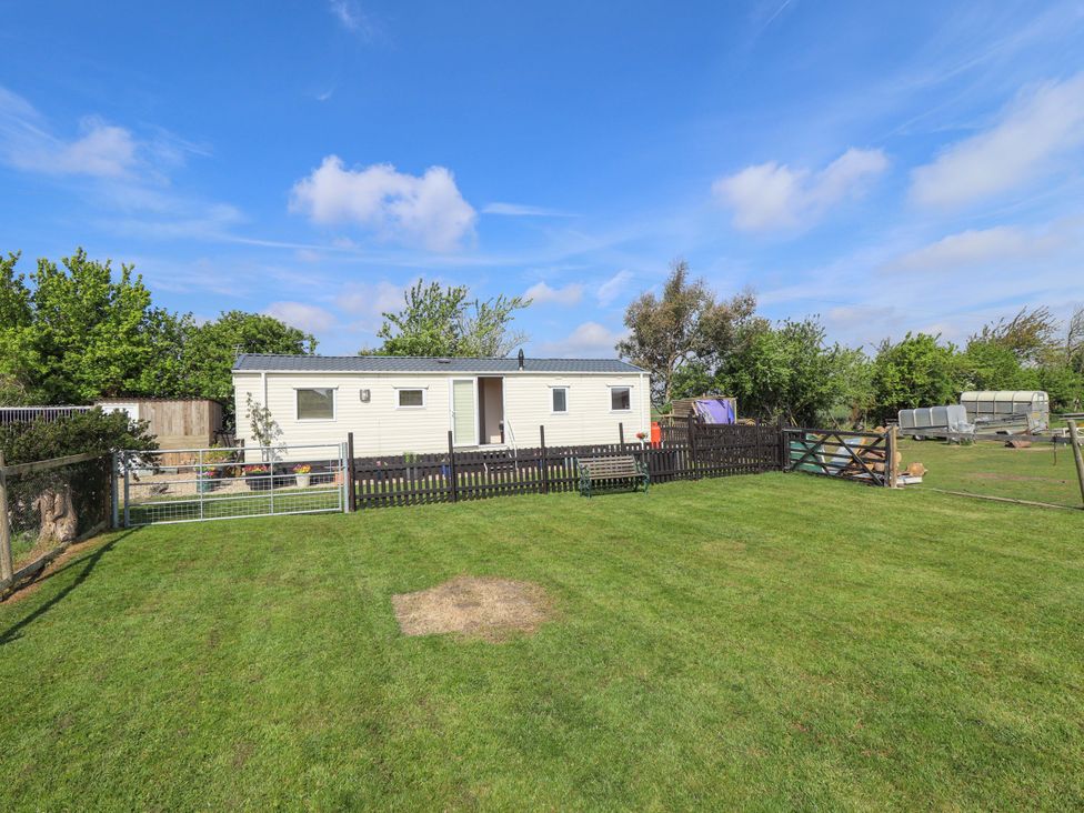 An outdoor area with a trailer and fenced yard at Ewe View