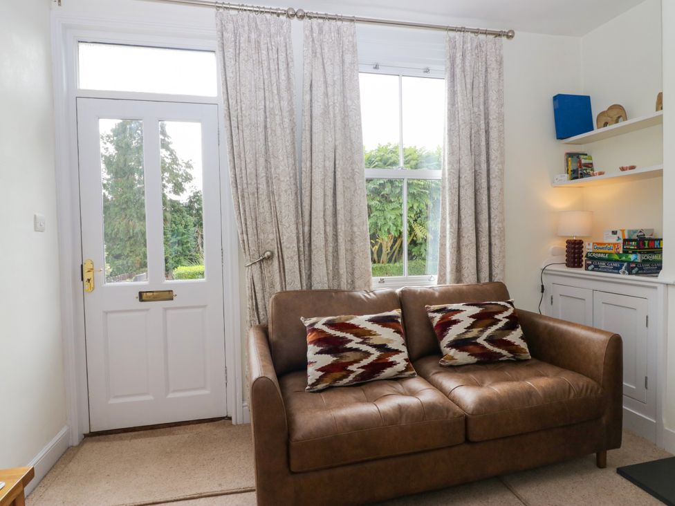 A living room with a sofa and shelves at 8 Railway Cottages in Ulverston