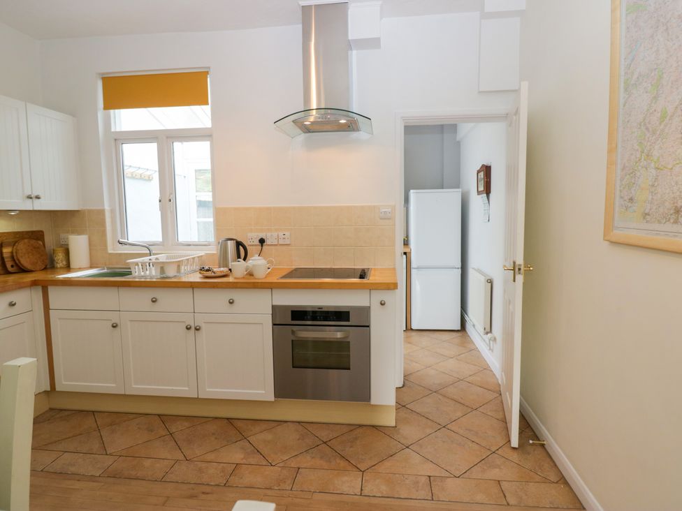 A kitchen with cabinets and a refrigerator at 8 Railway Cottages Ulverston
