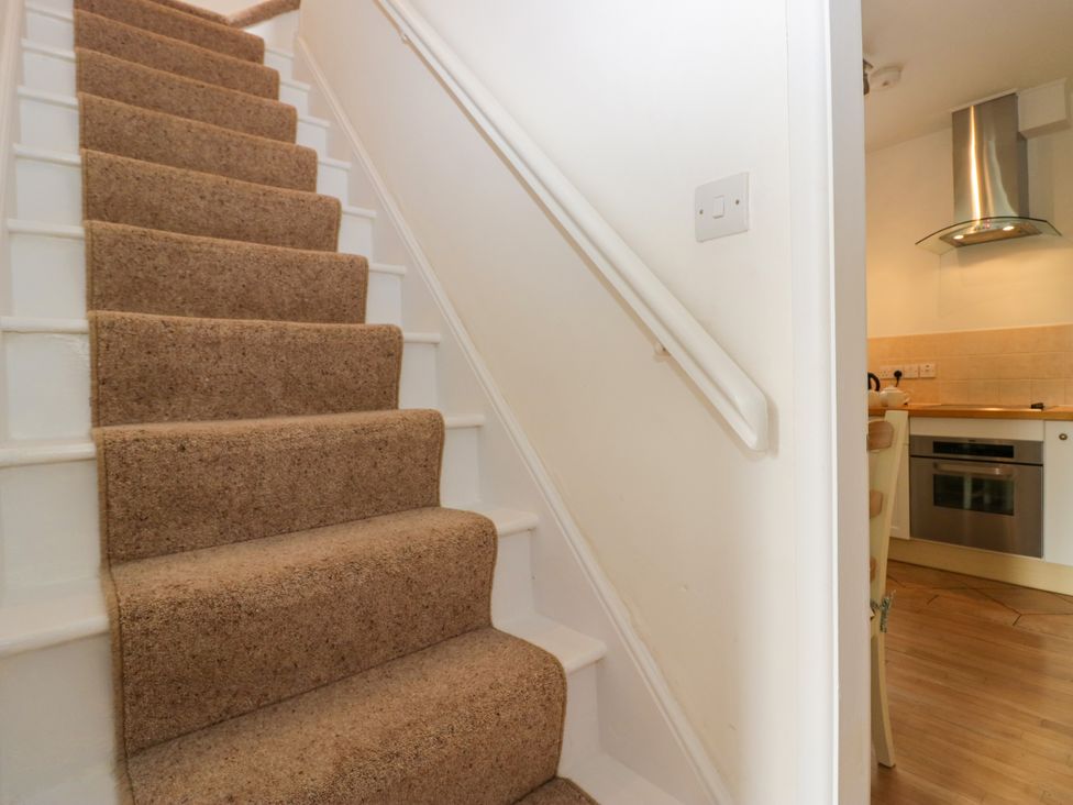 A staircase leading to a kitchen area at 8 Railway Cottages in Ulverston