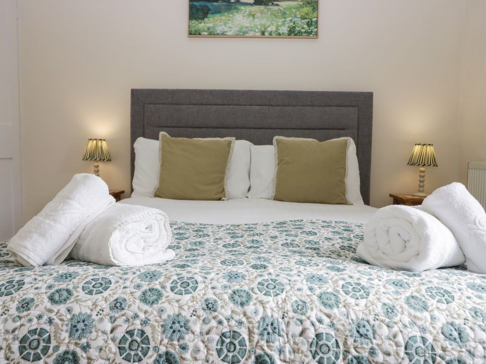 A bedroom with a bed and pillows at 8 Railway Cottages Ulverston