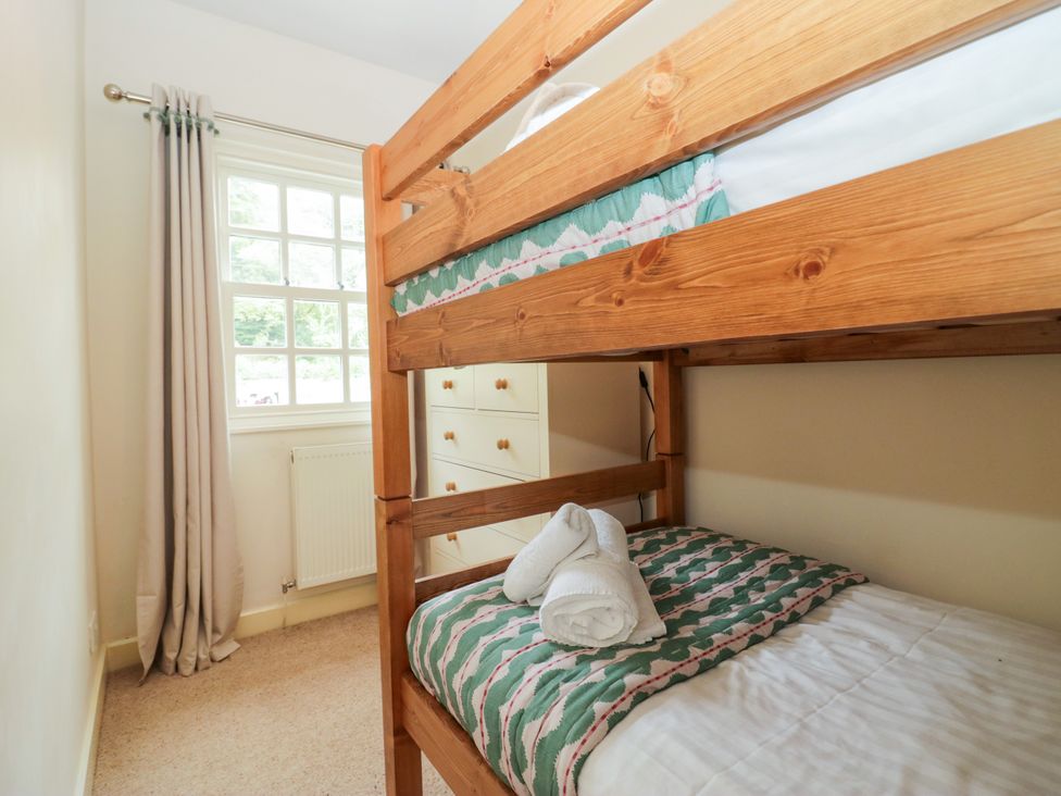 A bedroom with a bunk bed and a dresser at 8 Railway Cottages in Ulverston
