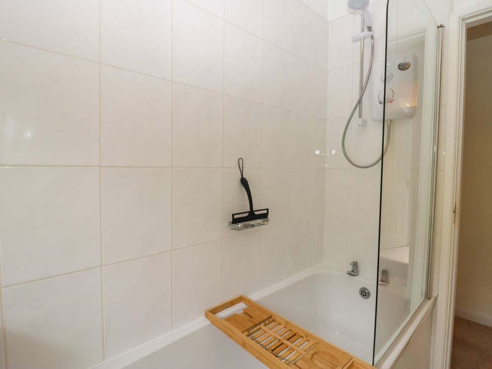 A bathroom with a bathtub and shower head at 8 Railway Cottages Ulverston