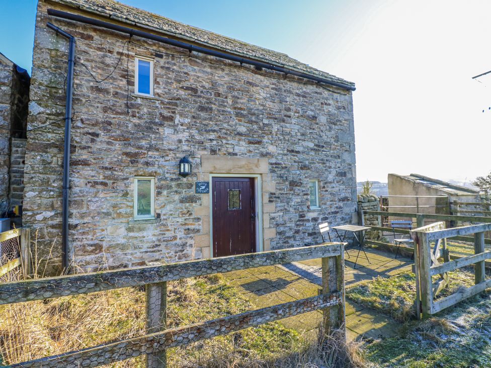 A stone building with a door and windows outside Dove Cottage in Hexham
