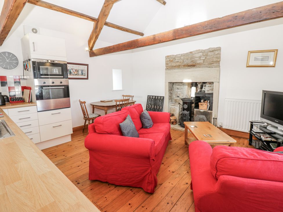 A living room with a sofa and fireplace at Dove Cottage in Hexham