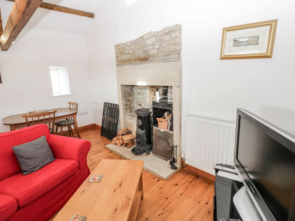 A living room with a fireplace and seating area at Dove Cottage in Hexham