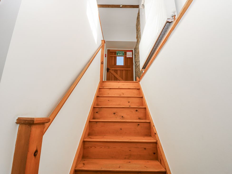 A staircase with wooden steps and a door at Dove Cottage Hexham