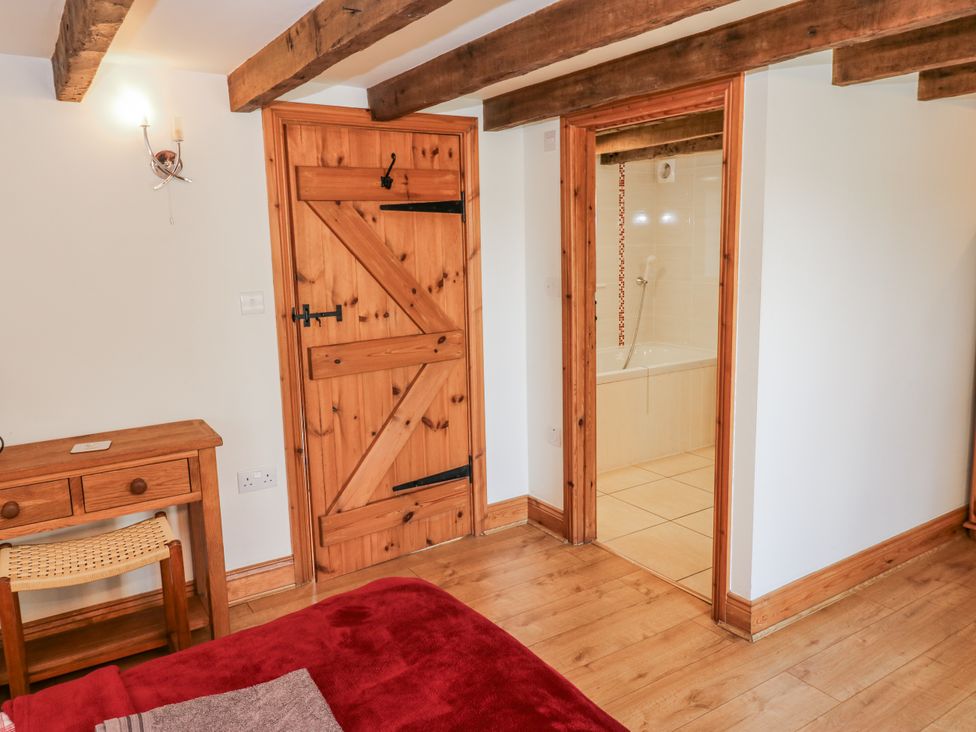 A bedroom with a wooden desk and door at Dove Cottage in Hexham