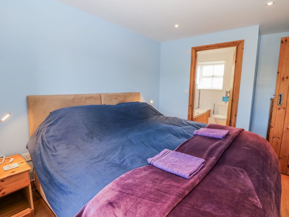 A bedroom with a large bed and a nightstand at Swallows Rest in Hexham