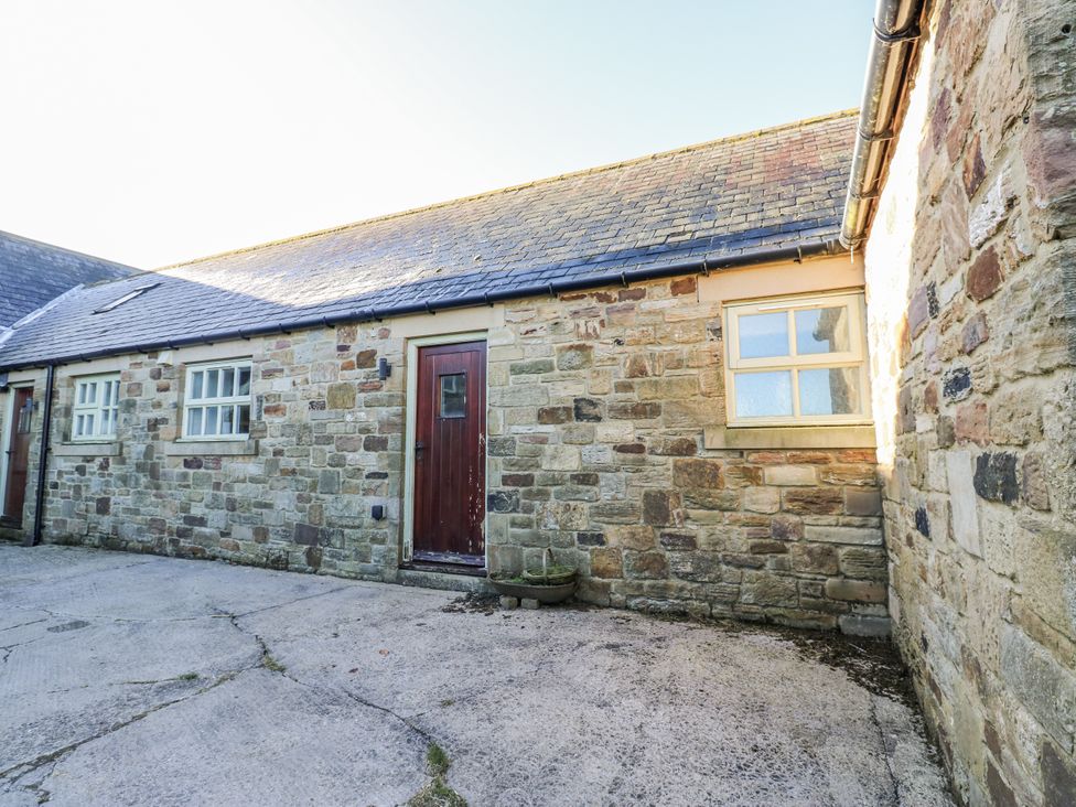 An outdoor area with stone walls and a door at Swallows Rest in Hexham