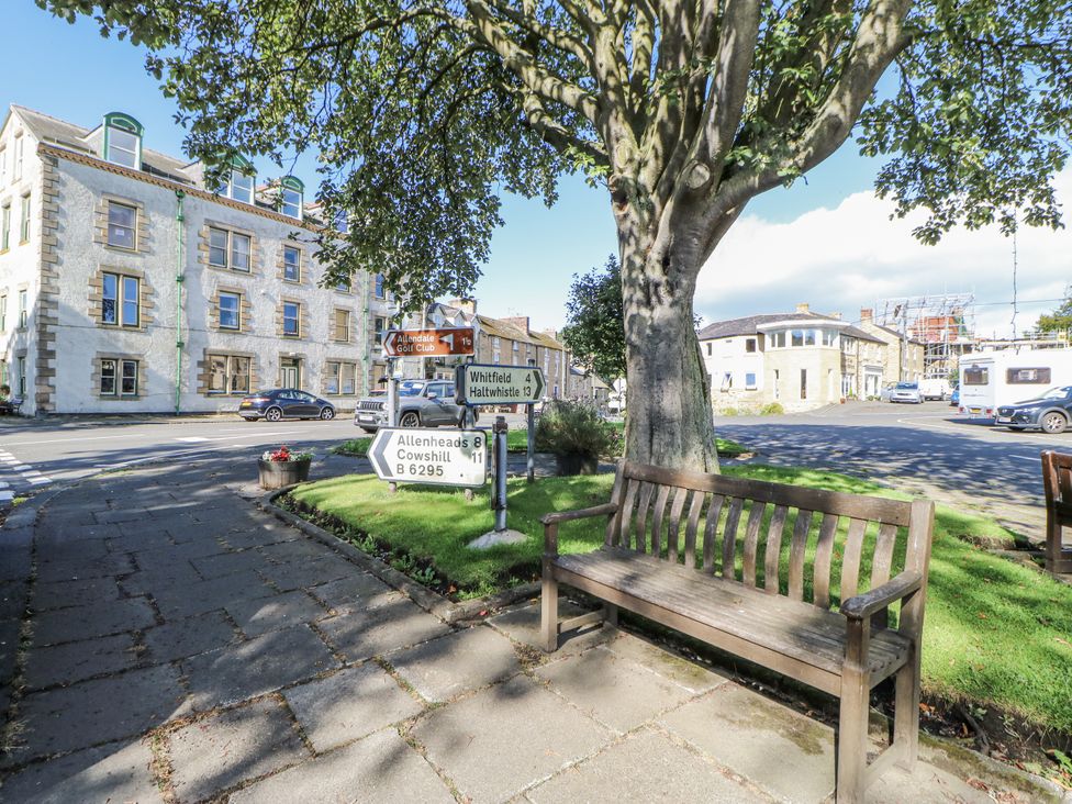 An outdoor area with a bench and road signs at Swallows Rest in Hexham