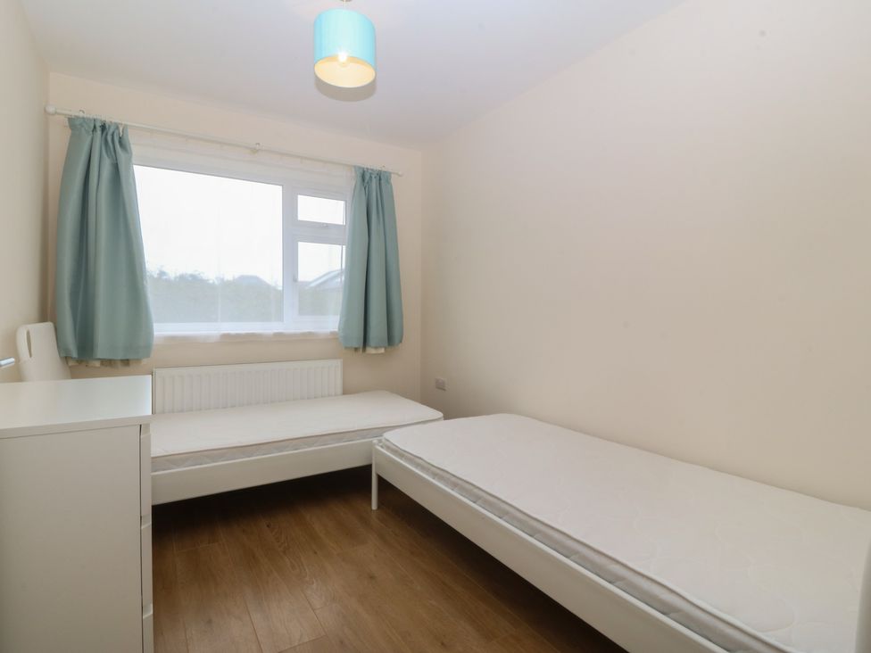 A bedroom with two beds and a window at Orme View in Penmaenmawr