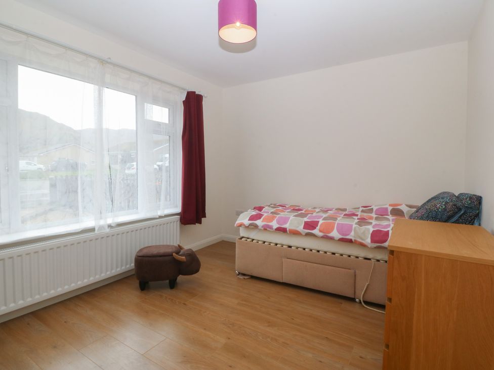 A bedroom with a bed and a window at Orme View in Penmaenmawr