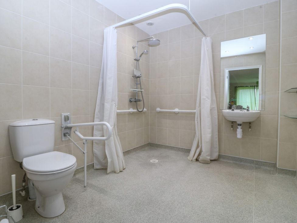 A bathroom with a shower, sink, and toilet at Orme View in Penmaenmawr