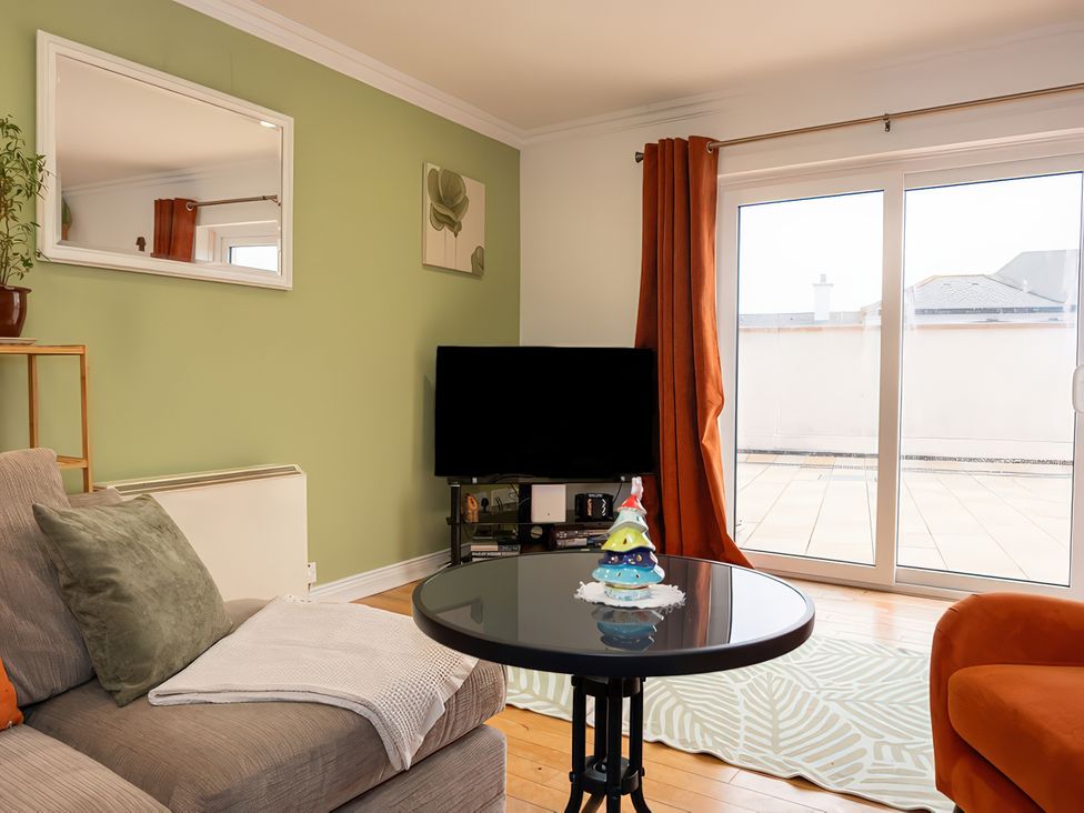 A living room with a sofa, television, and coffee table at Enniskillen hideaway in Enniskillen
