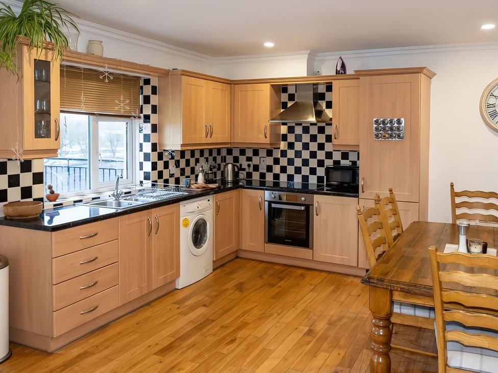 A kitchen with cabinets, countertop and table at Enniskillen hideaway Enniskillen