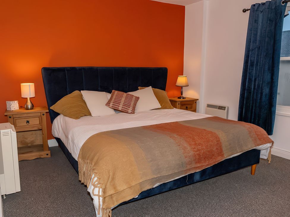 A bedroom featuring a bed with a blanket and nightstands at Enniskillen hideaway in Enniskillen