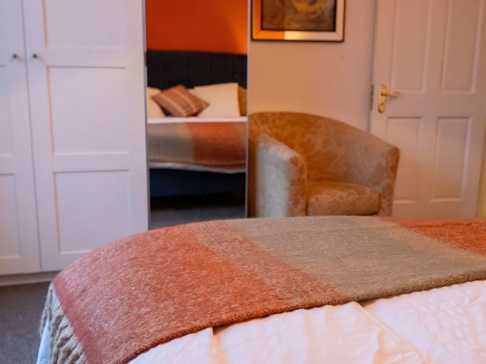 A bedroom with a bed, throw blanket, wardrobe and chair at Enniskillen hideaway Enniskillen