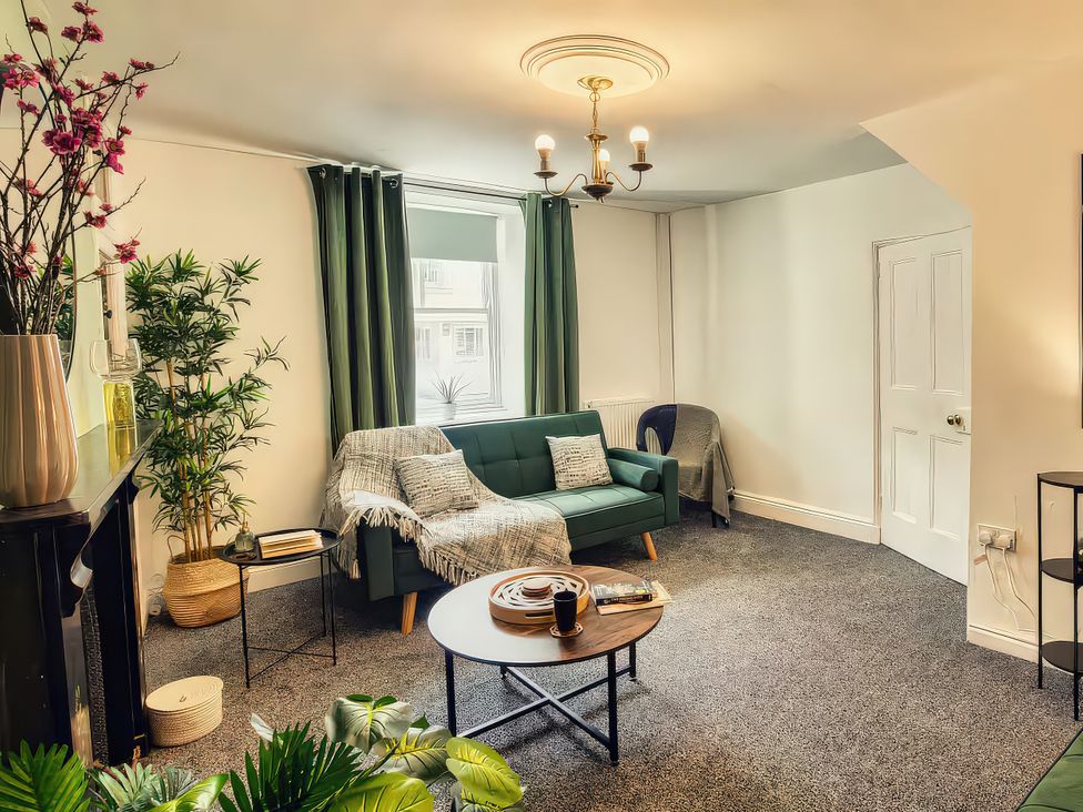 A living room with a sofa and table at 20 Bridge Street in Morpeth