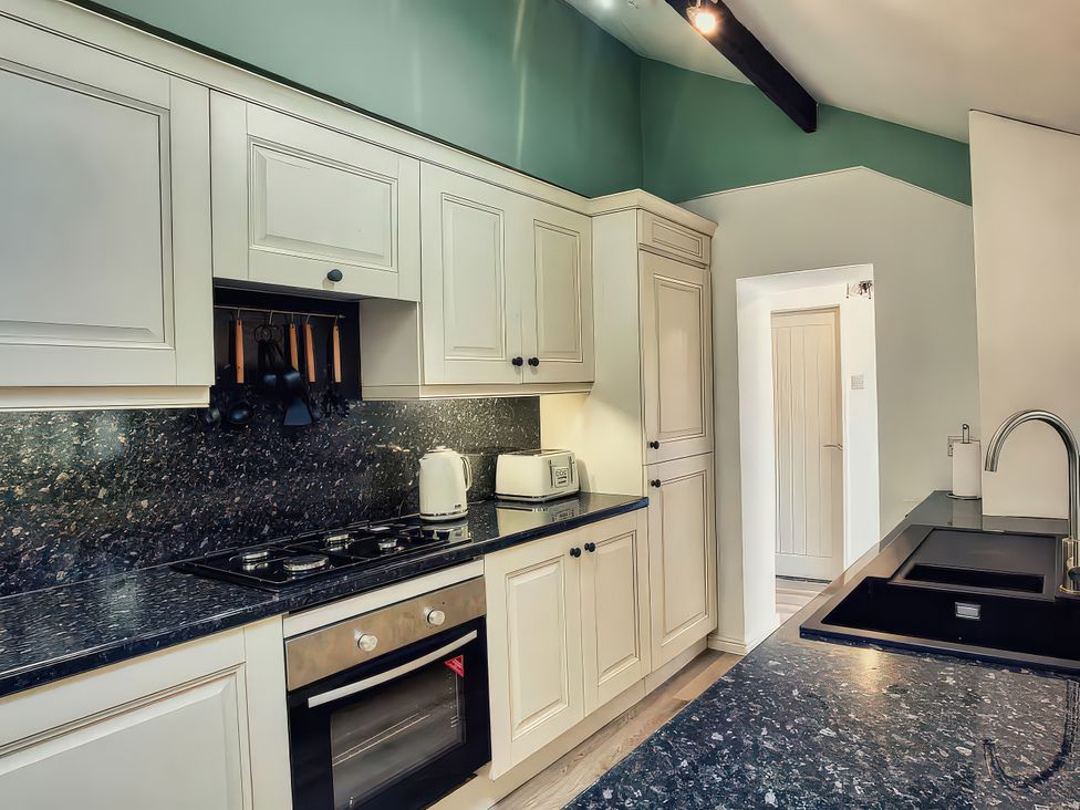 A kitchen with cabinets and appliances at 20 Bridge Street in Morpeth