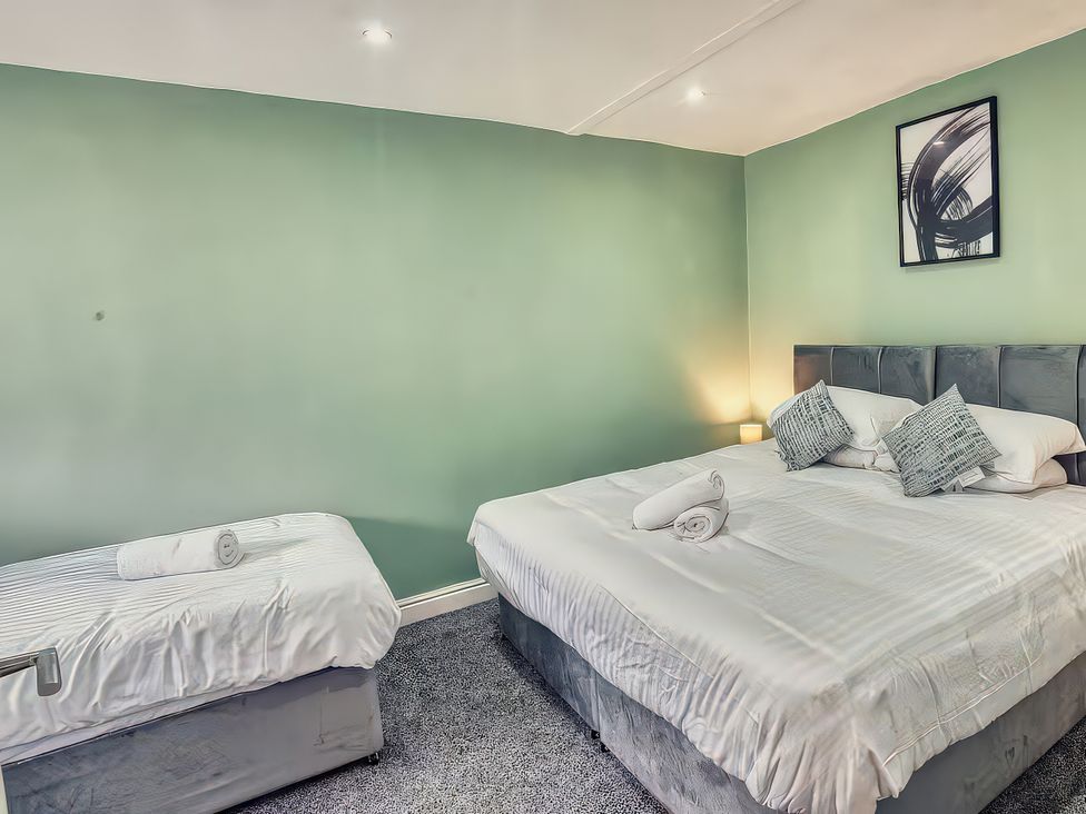 A bedroom with two beds and a piece of wall art at 20 Bridge Street in Morpeth