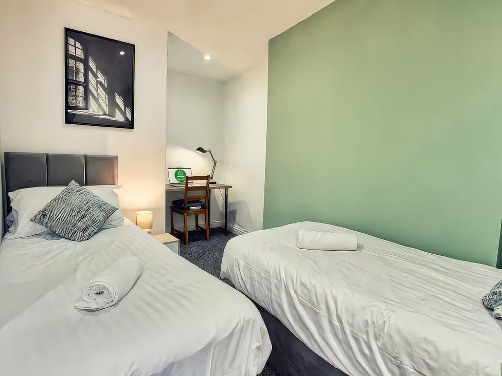 A bedroom with two beds and a desk at 20 Bridge Street Morpeth
