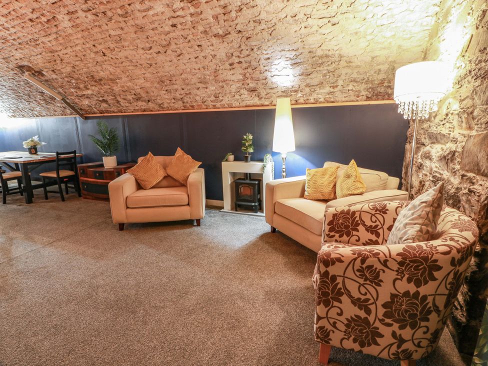 A living room with sofas and a dining area at 69 High Street in Gatehouse Of Fleet