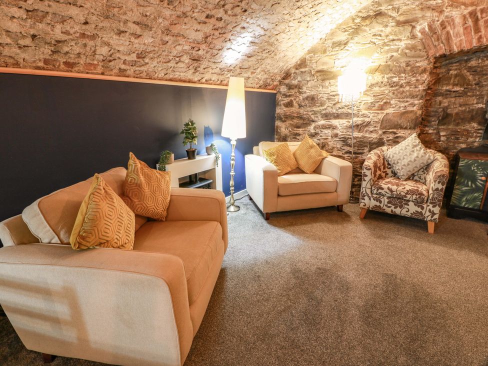 A snug with armchairs and a floor lamp at 69 High Street, Gatehouse Of Fleet