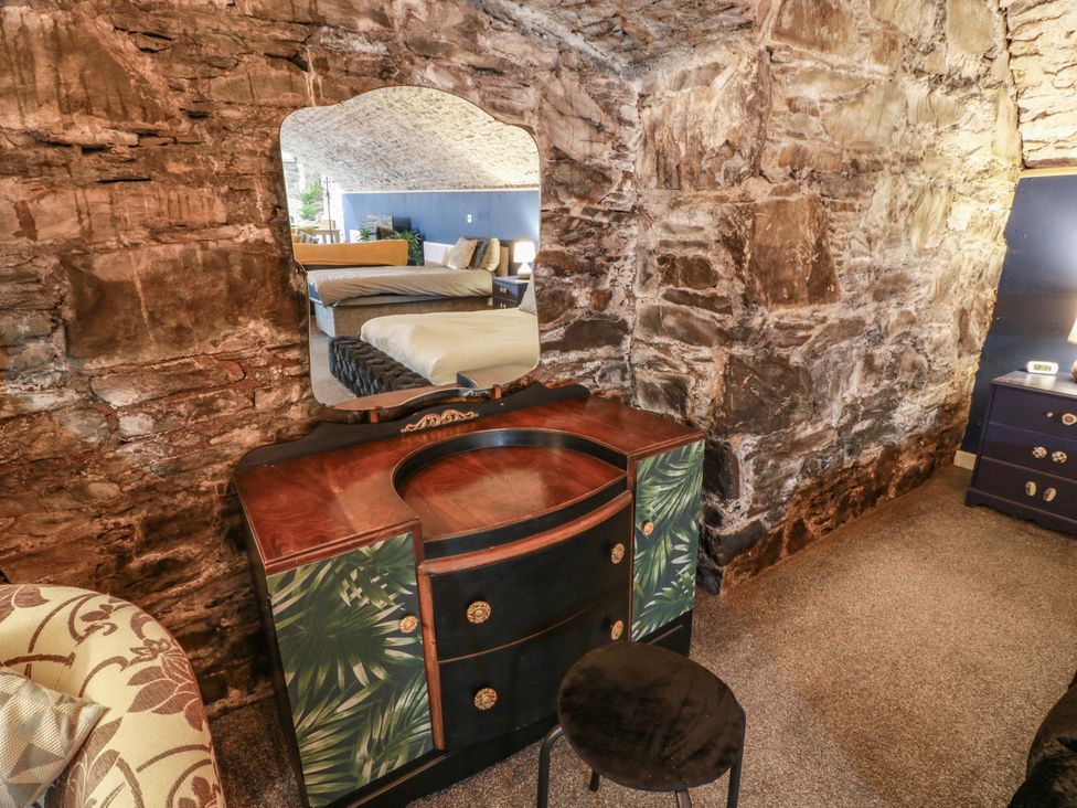 A bedroom with a vanity and mirror at 69 High Street Gatehouse Of Fleet