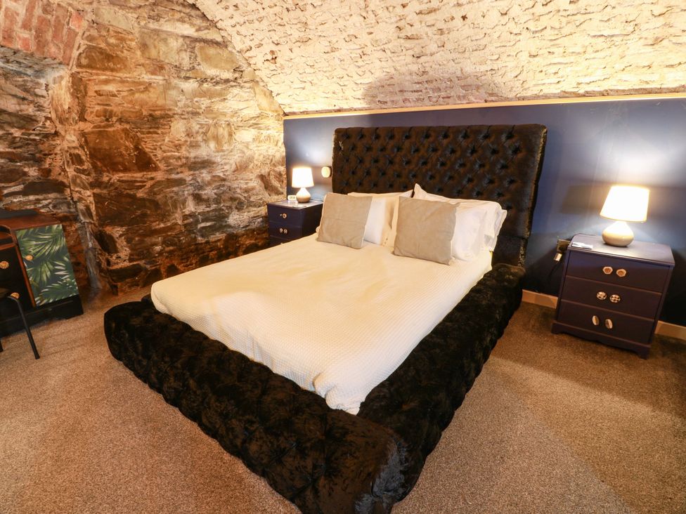 A bedroom with a bed and nightstands at 69 High Street in Gatehouse Of Fleet