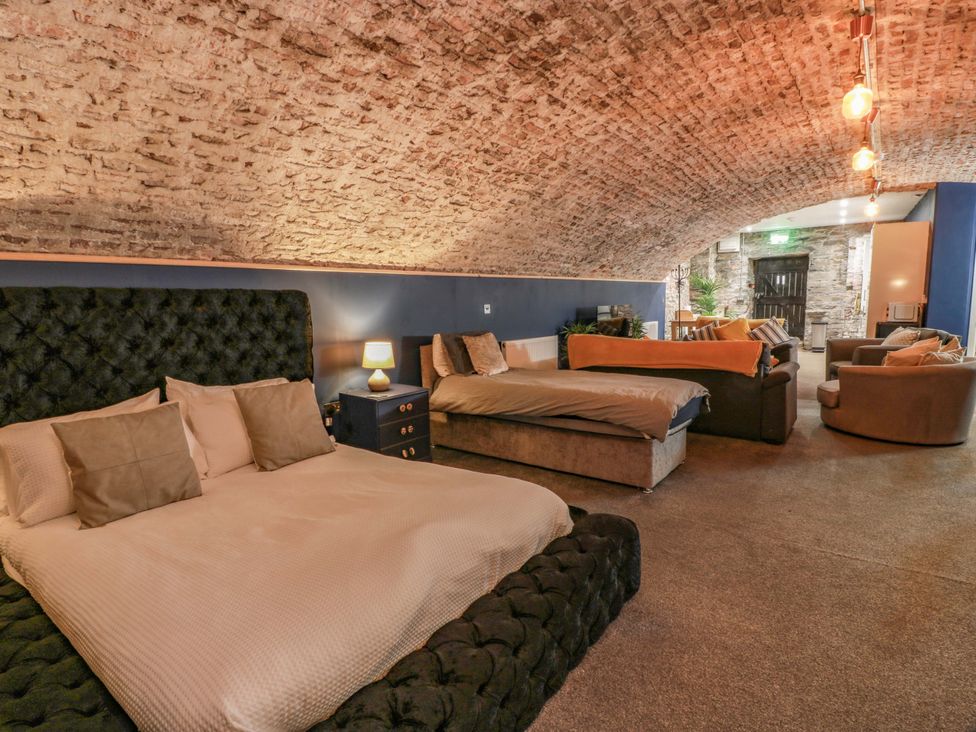 A bedroom with two beds and seating area at 69 High Street Gatehouse Of Fleet