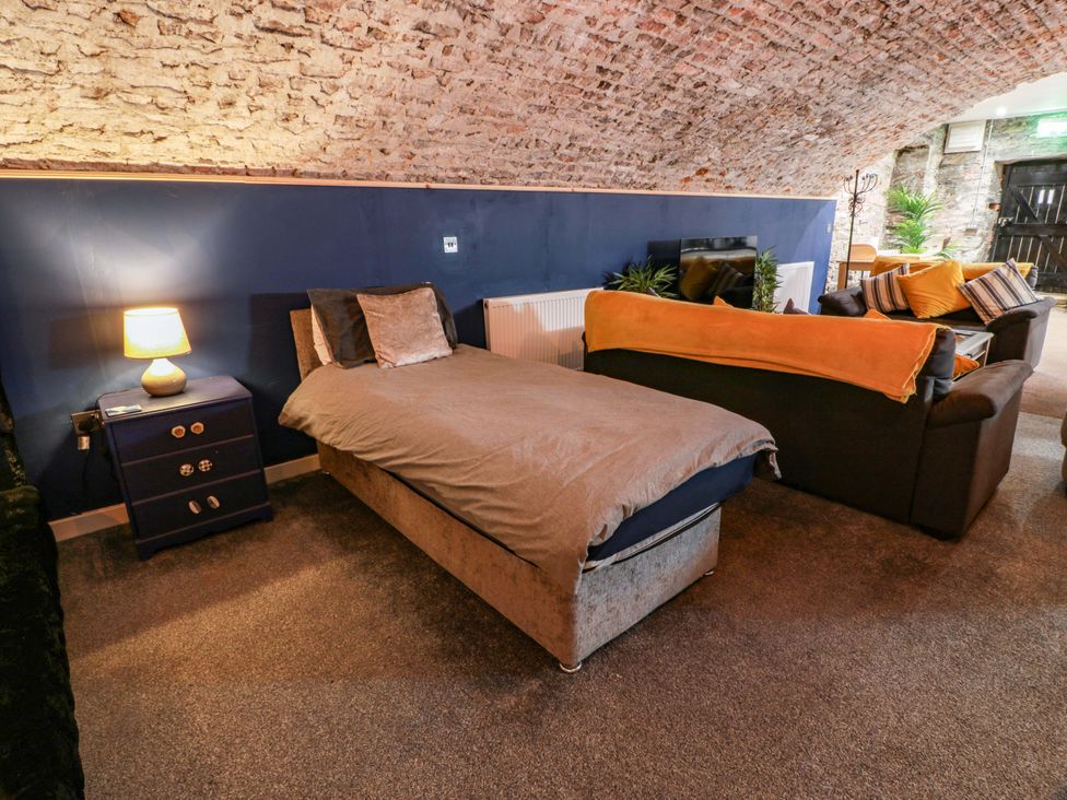 A living room with a bed and sofa at 69 High Street, Gatehouse Of Fleet