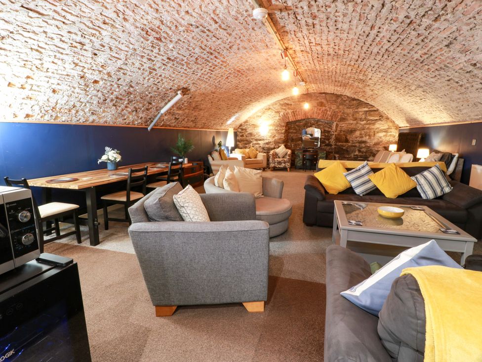 A living room with a dining table and seating area at 69 High Street Gatehouse Of Fleet
