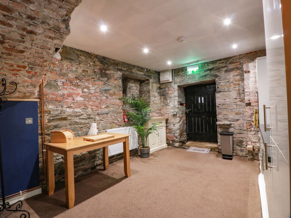 An entrance hall with a brick wall and a table at 69 High Street Gatehouse Of Fleet