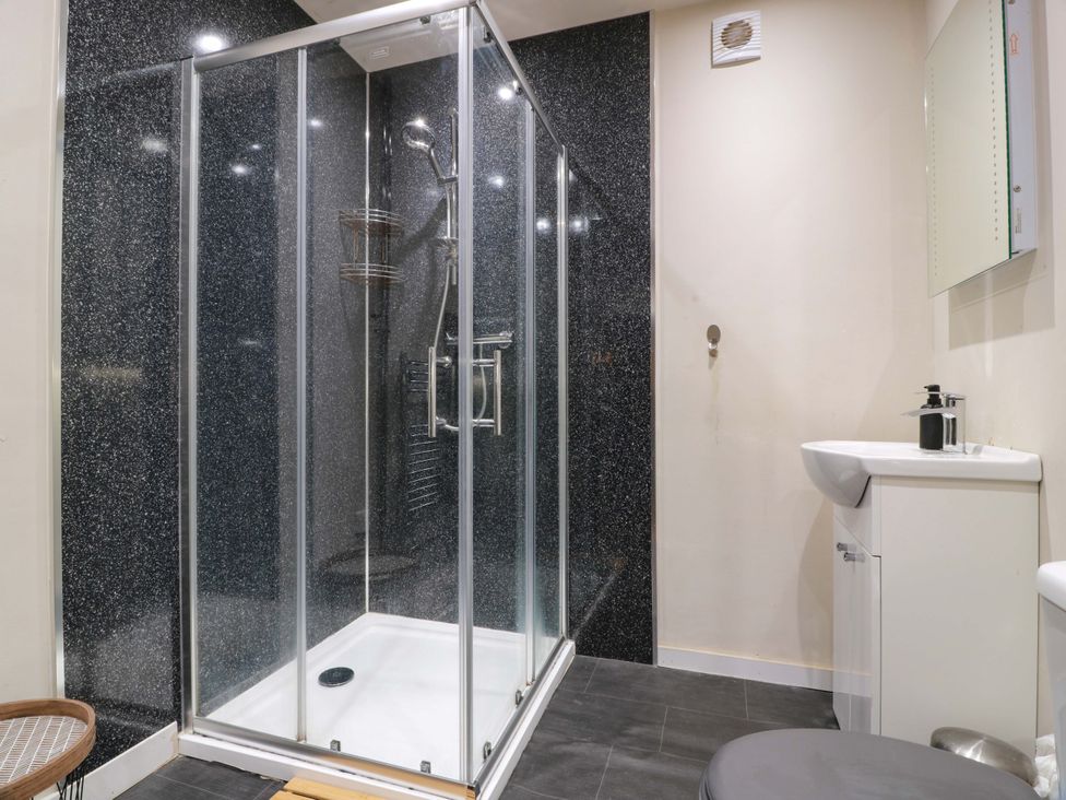 A bathroom with shower, toilet, and sink at 69 High Street Gatehouse Of Fleet