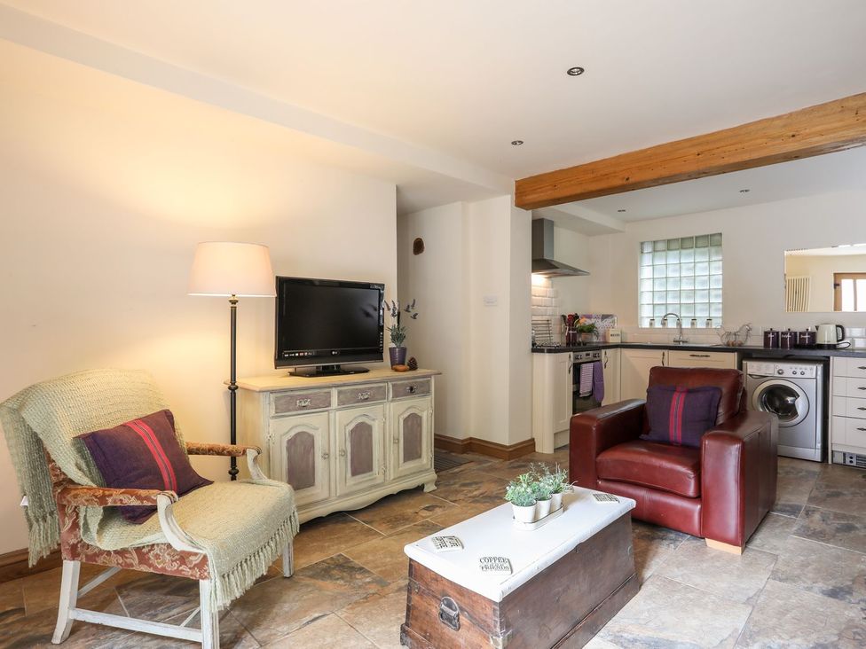 A living room with a television and coffee table at Llys Elen in Caernarfon