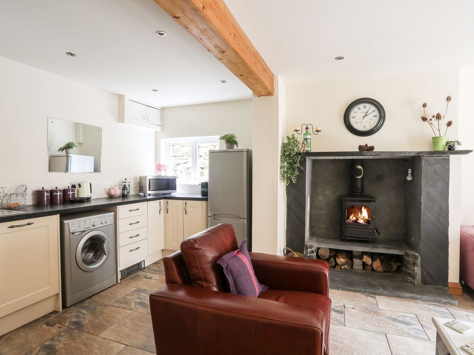 A kitchen with appliances and seating area at Llys Elen Caernarfon