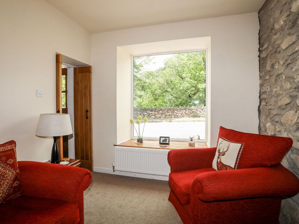 A living room with a window and seating at Llys Elen in Caernarfon