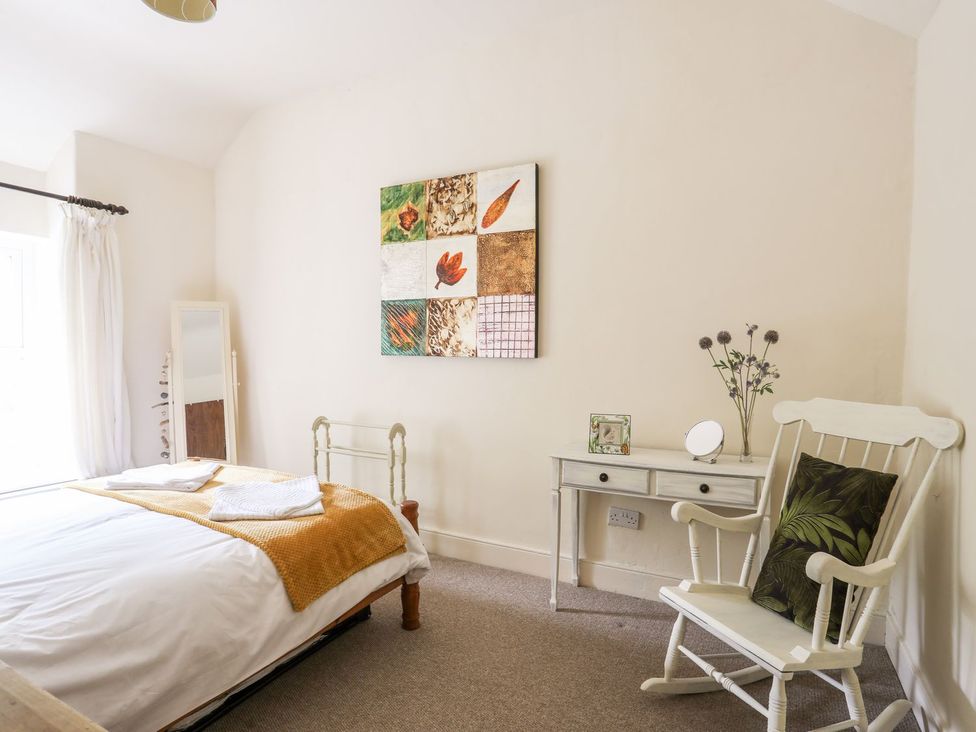 A bedroom with a bed and a chair at Llys Elen in Caernarfon