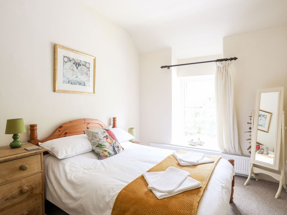 A bedroom featuring a bed with pillows and towels at Llys Elen in Caernarfon
