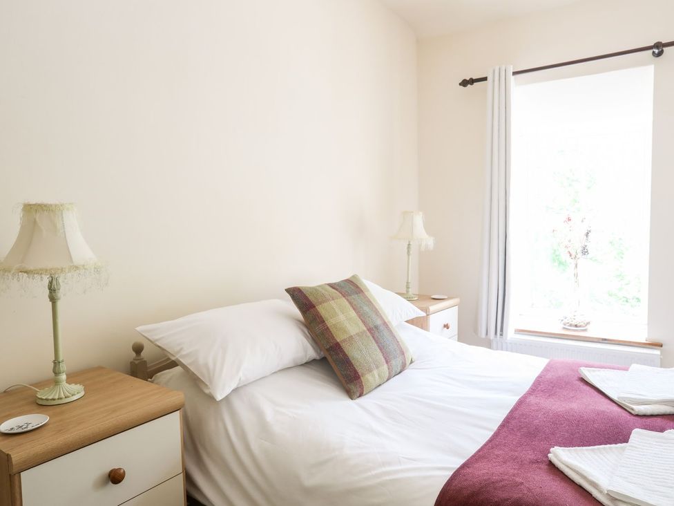 A bedroom with a bed and lamp at Llys Elen in Caernarfon