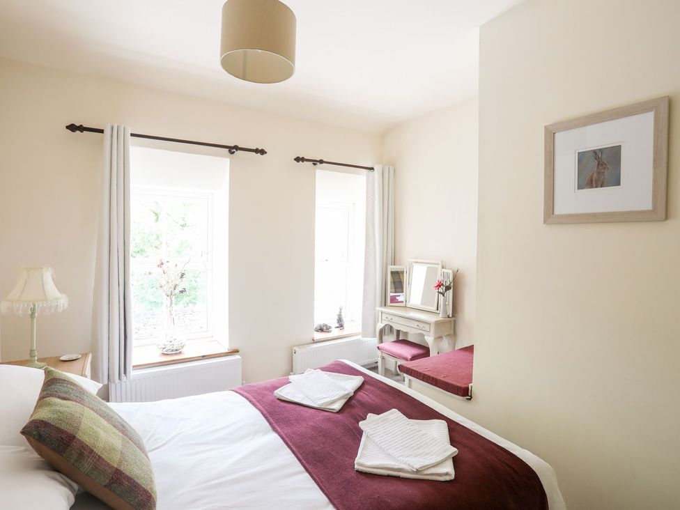 A bedroom with a bed and a mirror at Llys Elen in Caernarfon