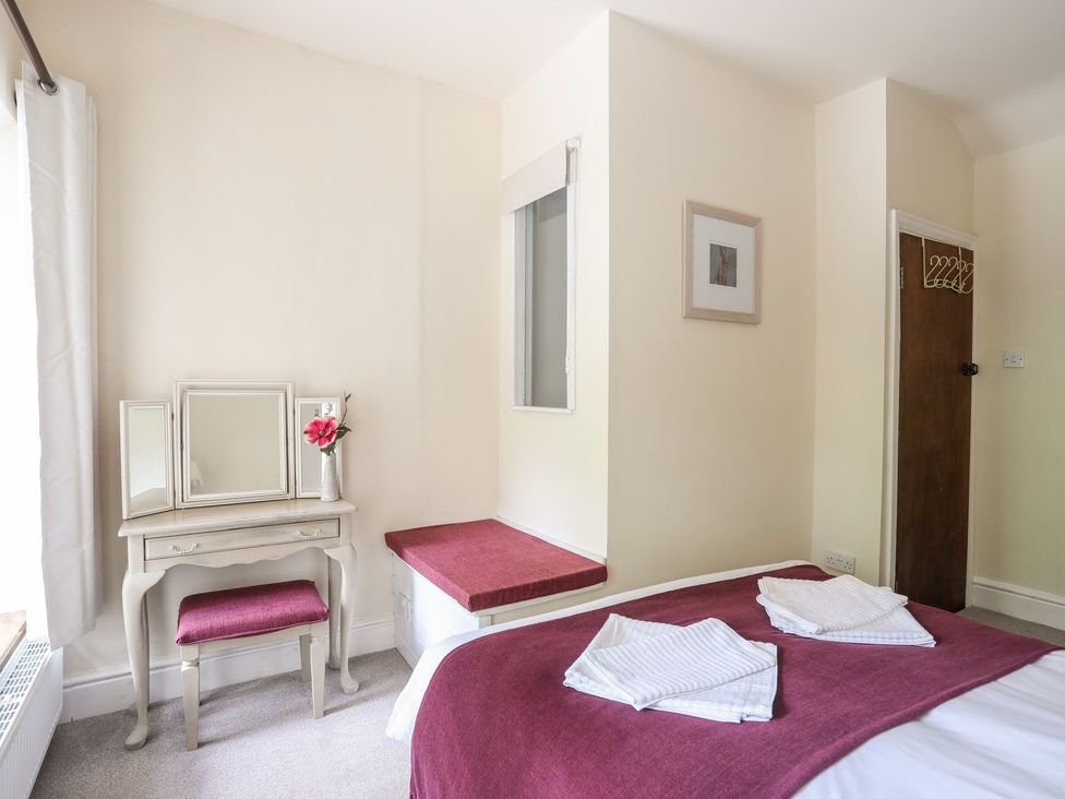 A bedroom with a mirror and table at Llys Elen in Caernarfon