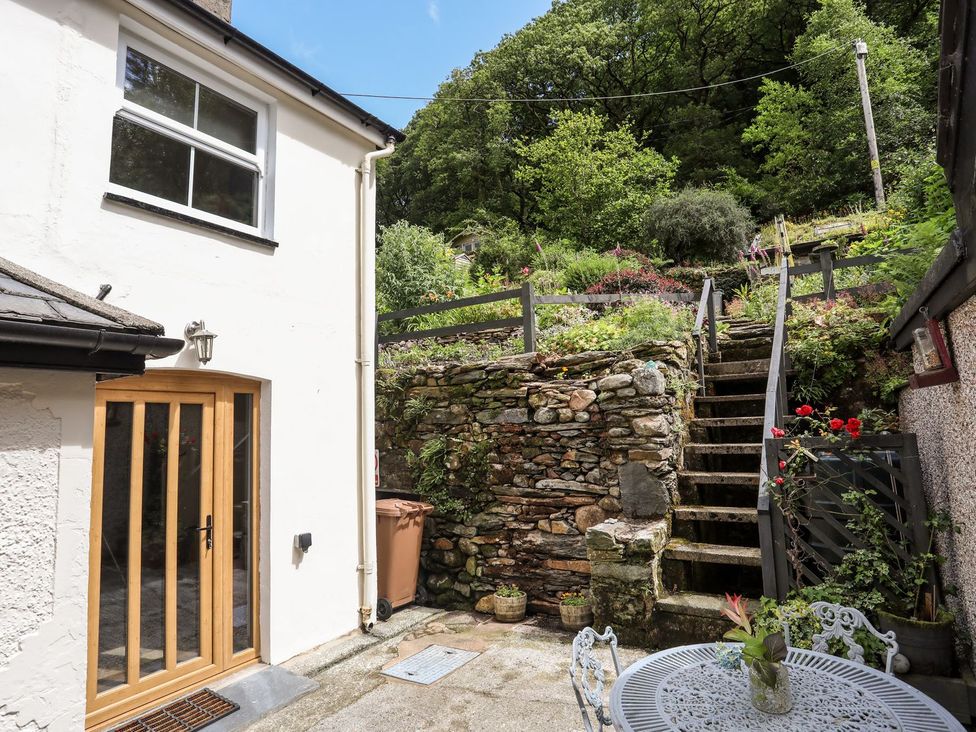 A garden with steps leading to an upper area and a seating arrangement at Llys Elen Caernarfon