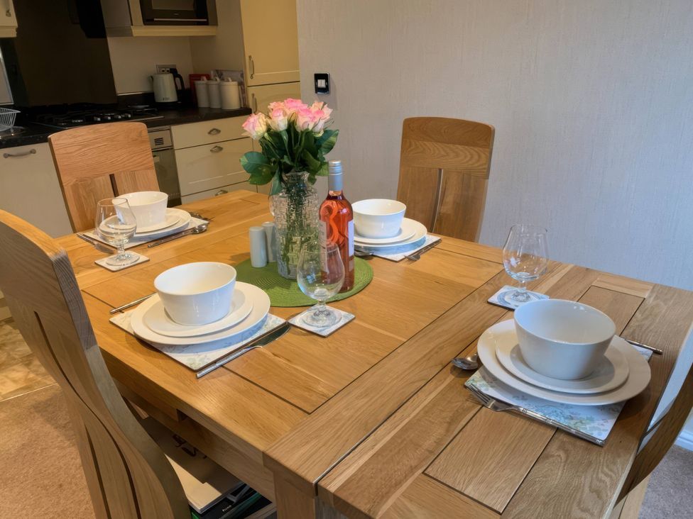 A dining table set with plates and glasses at Tiggywinkle Beck - White Cross Bay, Windermere